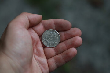 Antique silver coin one rupee of India in hand