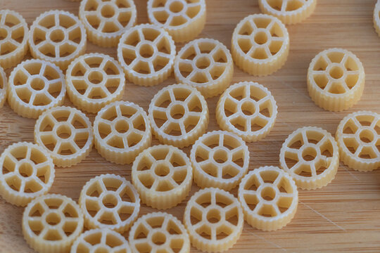 A grid of small pasta wheels, arranged on the table in an organized pattern