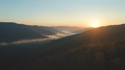 Serene Dawn Over Mountain Ridges: Misty Valley Landscape at Sunrise