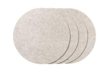 Four round beige felt coasters stacked on a transparent background isolated on transparent...