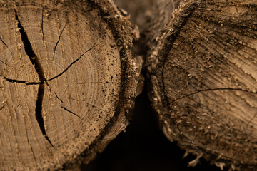 Pile of split firewood, ready for burning. Close-up of weathered wooden planks showing knots and...