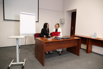 Two women discussing business issues, analyzing information.
