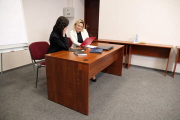 Two women discussing business issues, analyzing information.