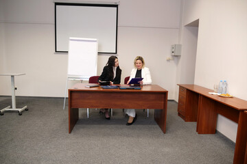 Two women discussing business issues, analyzing information.