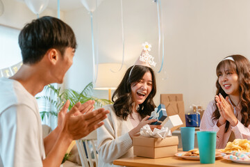 Asian birthday celebrate friends party. Happy birthday companionship enjoyment. Friendship emotion group laughing. Group friends partying birthday cake home. People playful anniversary. Friendship.