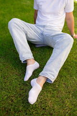 Male foot in white sock on the background of grass. Man foot with sock on.