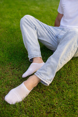 Male foot in white sock on the background of grass. Man foot with sock on.