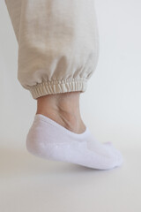Female foot in white sock on white background