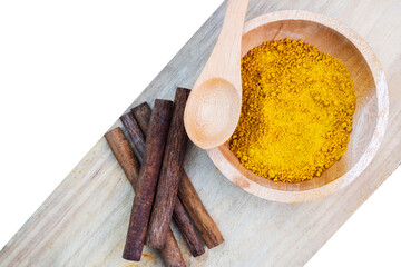 spices in a wooden bowl and cinnamon stick on wooden cutting board with transparent edges