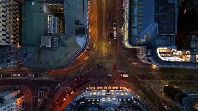 Aerial top down view of the illuminated streets at the City of London, England, during dusk with car and pedestrian traffic