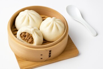 Soft steamed pork dumplings displayed on a plain white backdrop