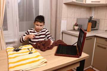 Boy wipes forks and kitchen knives. Housework.