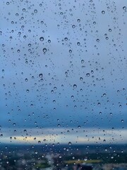 Raindrops on Window Glass with Soft Blue Sky – Abstract Mood Background