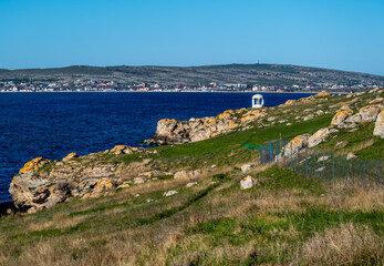 The seaside with rocks and a summer house in the afternoon.