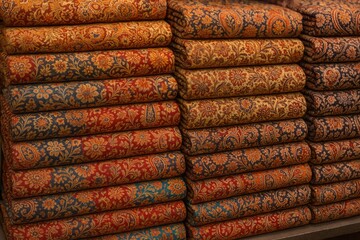 Textiles with intricate designs displayed on the table for trading.