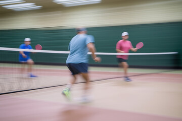 Intense pickleball match captured in action during indoor court play with players focused on the game