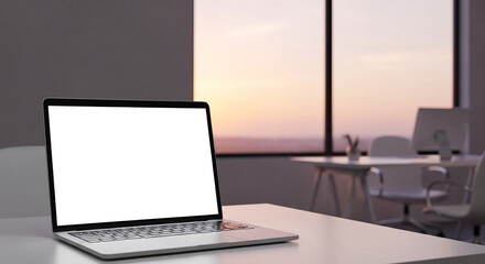 Laptop with blank white screen on office desk, blurred workspace background with window view and soft sunset light.