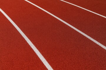 Fototapeta premium Red treadmill and stadium backdrop with white lines and stripes