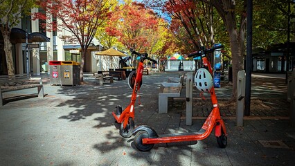 Rental electric scooters stand in the Canberra City Centre plaza. Australia. © Lucas