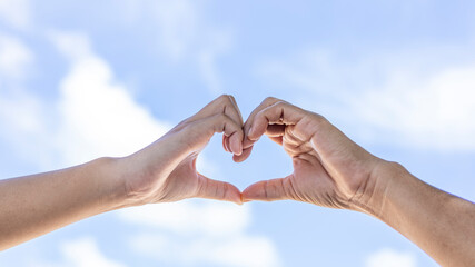 Hands Shape a Heart Against a Blue Sky