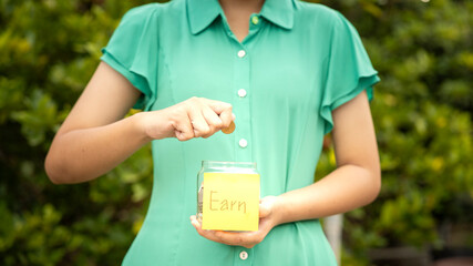 Person Saving Money in a Jar for Future Goals