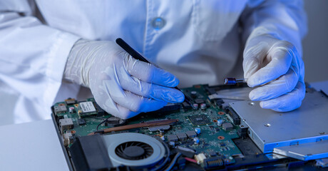 Tech Fixes Laptop at Night With Care