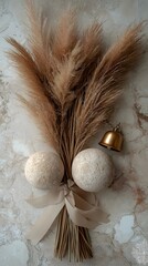 A decorative bouquet of pampas grass and ornaments is displayed on marble