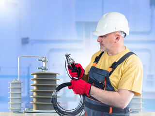Man electrician. Installation of energy infrastructure. Man electrician cuts wire. Construction of...
