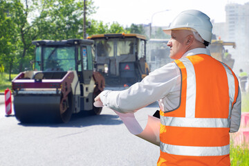 Fototapeta premium Man urban infrastructure architect. Asphalt pavers behind builder. Road architecture specialist. Asphalt paving on street. Man road worker in orange vest. Street build works. Art focus.