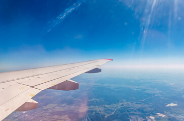 Fototapeta premium View from the airplane window at a beautiful cloudy sky and the airplane wing