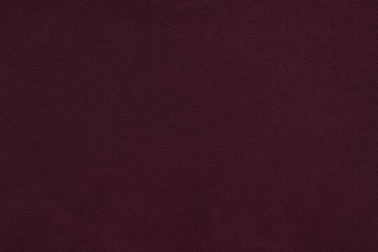 Close-up of deep purple matte suede with a velvety finish and seamless wine-colored leather texture, featuring felt material details