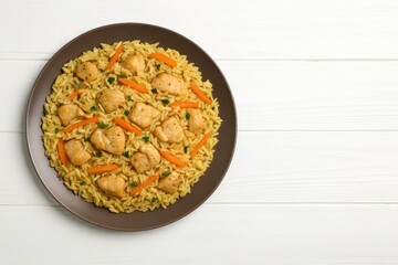 Tasty meat pilaf served on a white wooden surface from a top-down perspective