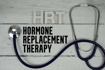 HRT Hormone replacement therapy text with Stethoscope on wooden background
