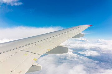 Obraz premium View from the airplane window at a beautiful cloudy sky and the airplane wing