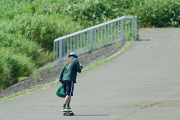  A person riding a skateboard on the riverbank