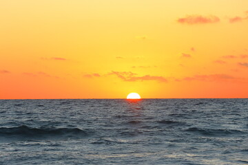 sunrise at sea with sun rays and waves