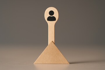 Close-up of a wooden stick with a hand-drawn person icon, supported by a triangular paper holder