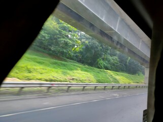 Naklejka premium Highway View from Vehicle with Trees and Guardrail 
