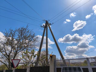 A tall, three-legged pole with wires coming out of it. The sky is blue with some clouds