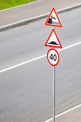 road sign warning of exit to embankment, vertical photo. danger to life while driving a car. risk of getting into a car accident. 