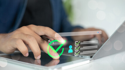 Close-up of hands using tablet and laptop with digital check mark and online checklist icon,...
