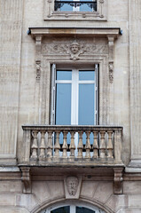 Ornate balcony featuring sculpted details on a historic building in Paris, France
