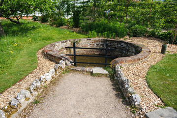 Brick well in a walled garden, England