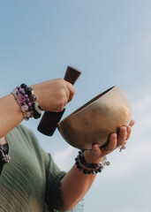 Close-up of female hands holding sound healing instruments. Tools for therapy, inner balance, and...