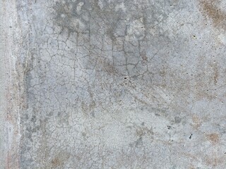Severely Cracked & Stained Concrete. A close-up of very old, grey concrete with an extensive network of fine cracks and rusty-brown discoloration