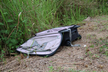 Abandoned Travel Suitcase in Tall Grass by Rural Roadside