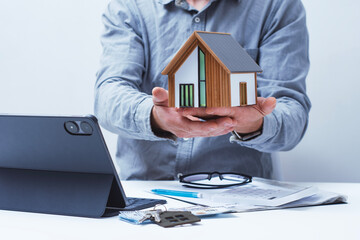 Model home with solar panels, with key documents and a tablet on the realtor's desk. Concepts of...