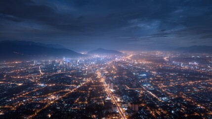 Fototapeta premium Aerial night view of cityscape with mountains in background