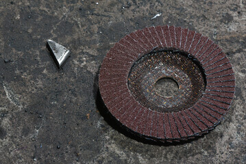 Grinding disc for angle grinder and metal workpiece close up background.