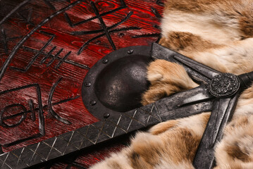 Old long medieval two handed knight warrior sword and viking wooden shield with ancient runes and...